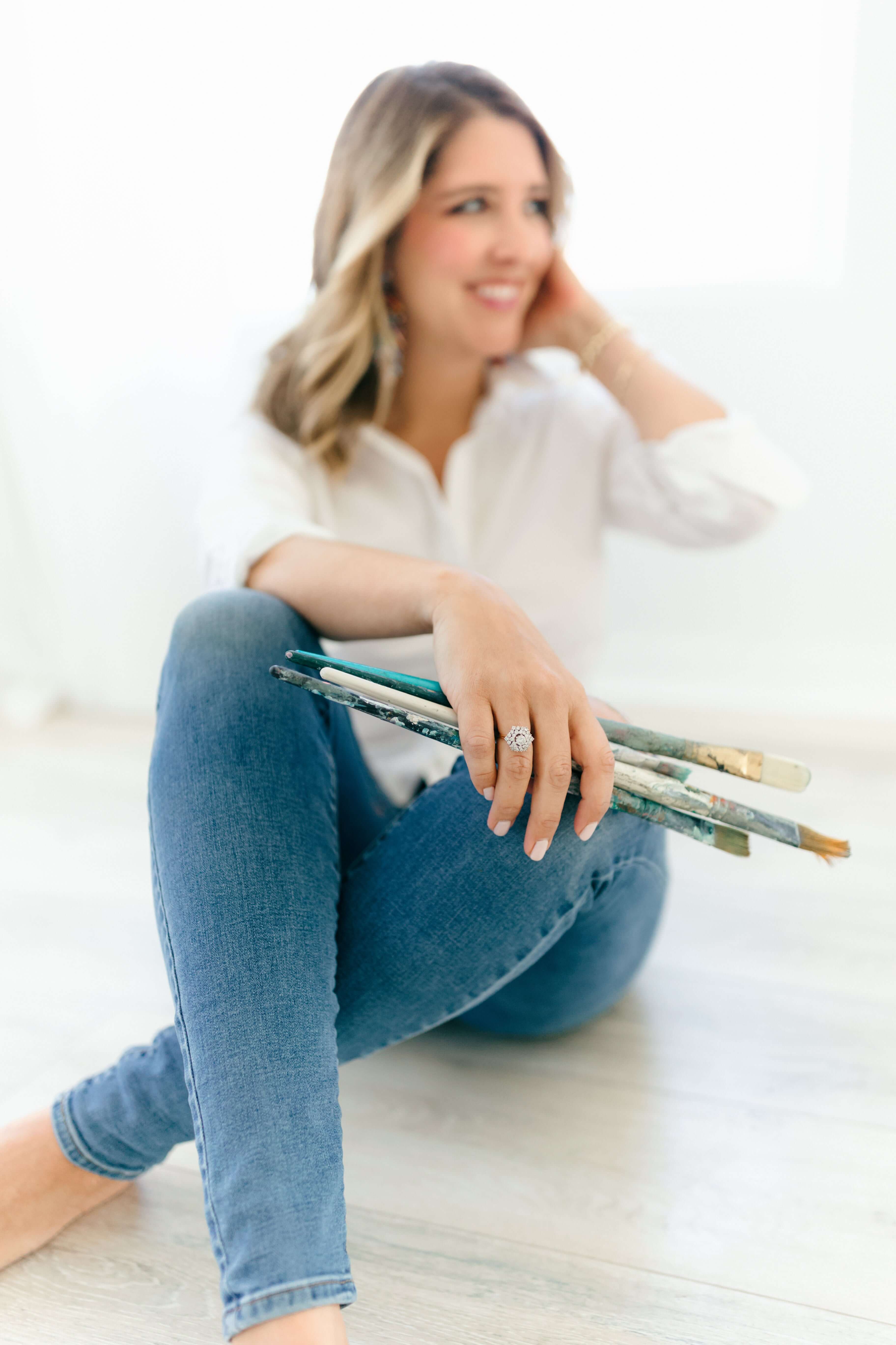 Candace with paintbrushes, smiling, casual portrait
