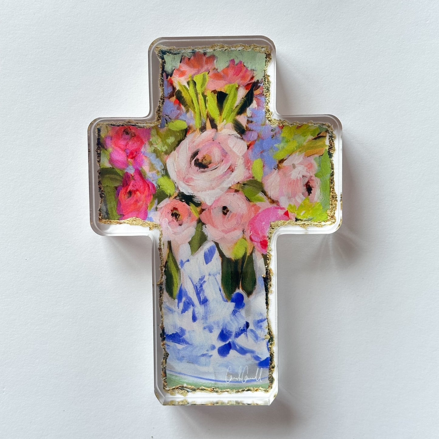 Cross-shaped art with flowers in a vase.