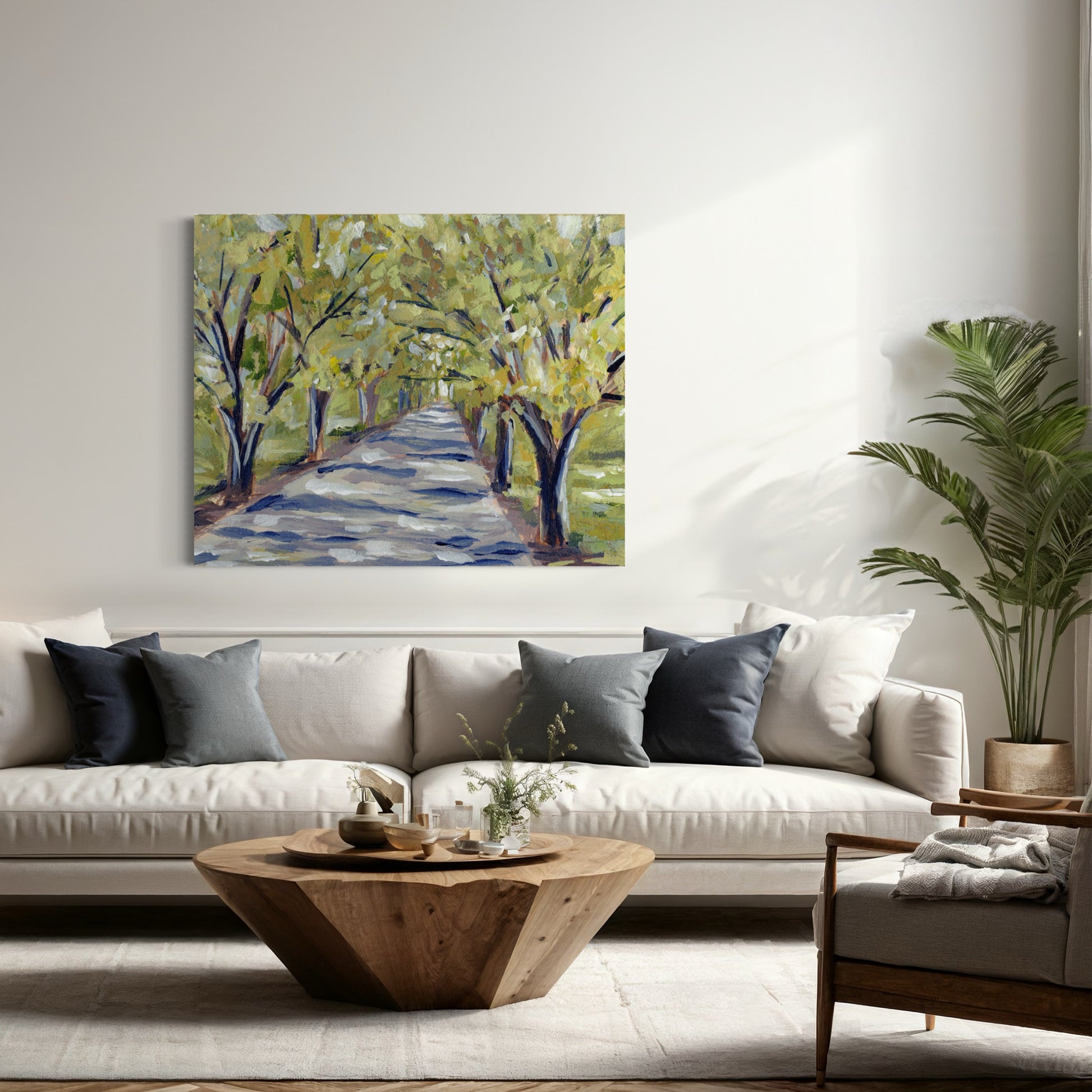 Painting of trees over a path, above a sofa.