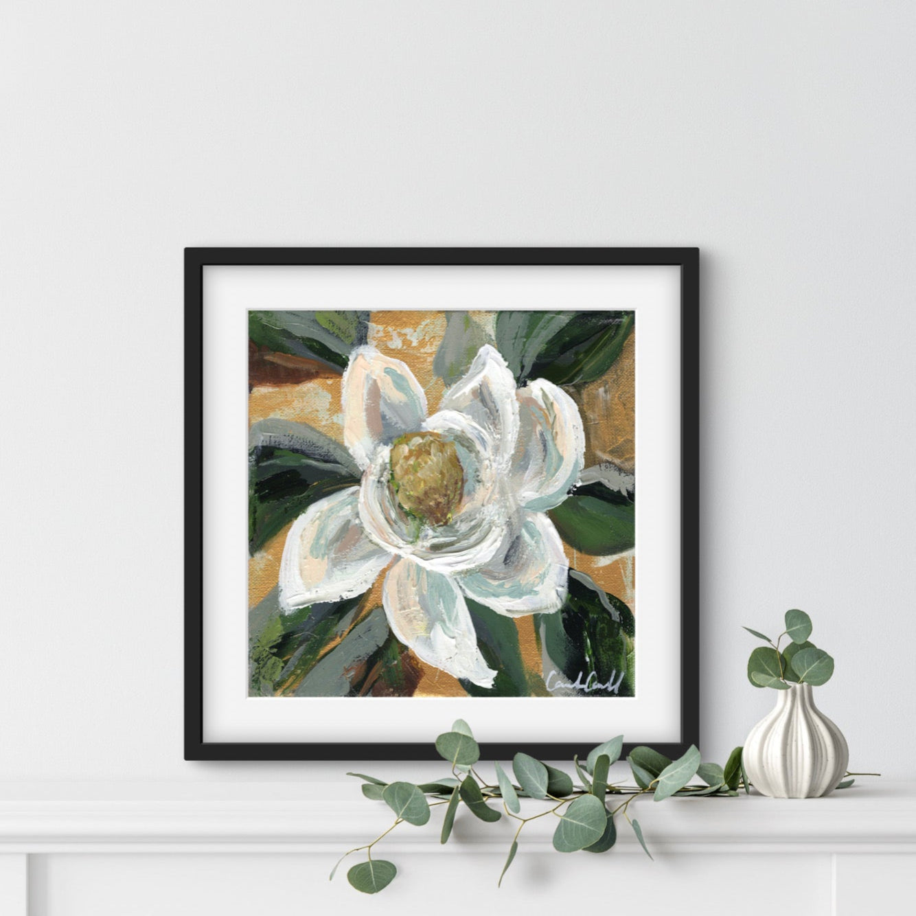 Painting of a white magnolia flower in a black frame.