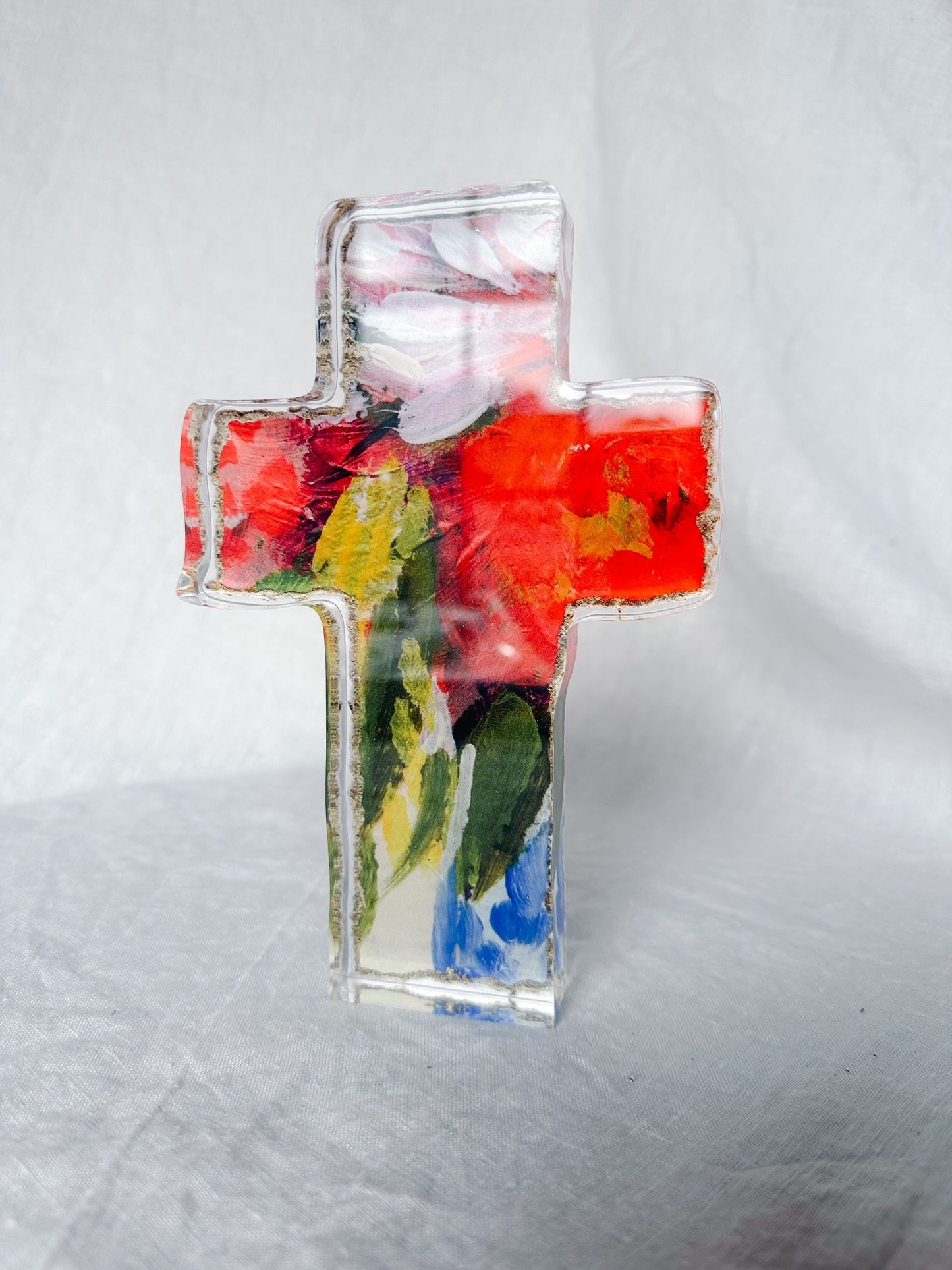 Vibrant red blue and white floral acrylic cross standing on shelf