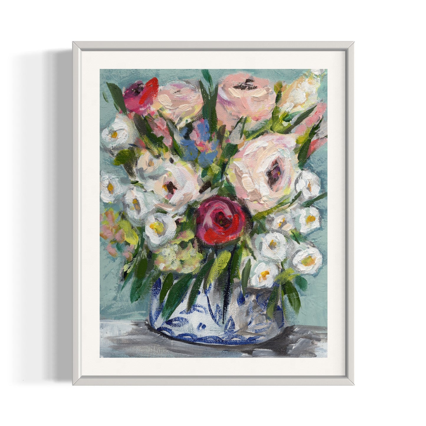 art print of floral bouquet with pink white, red, and blue flowers on aqua blue background framed in white frame on white wall