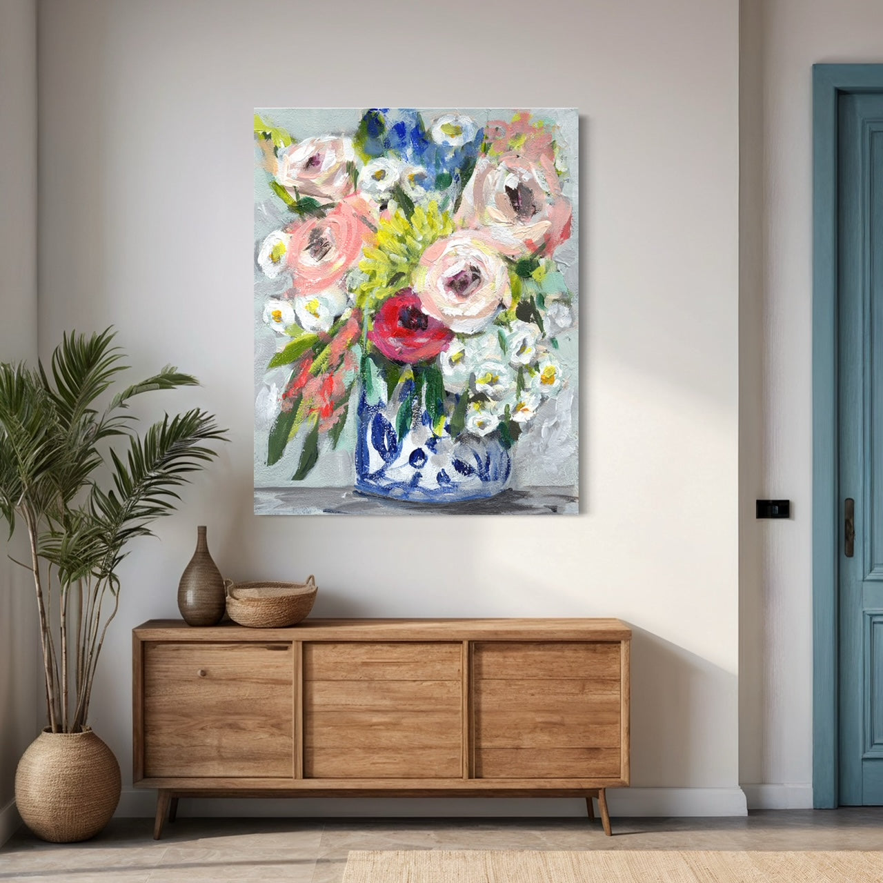 Floral bouquet with colors of pink, red, yellow and white on neutral grey background on white wall with warm wood cabinet