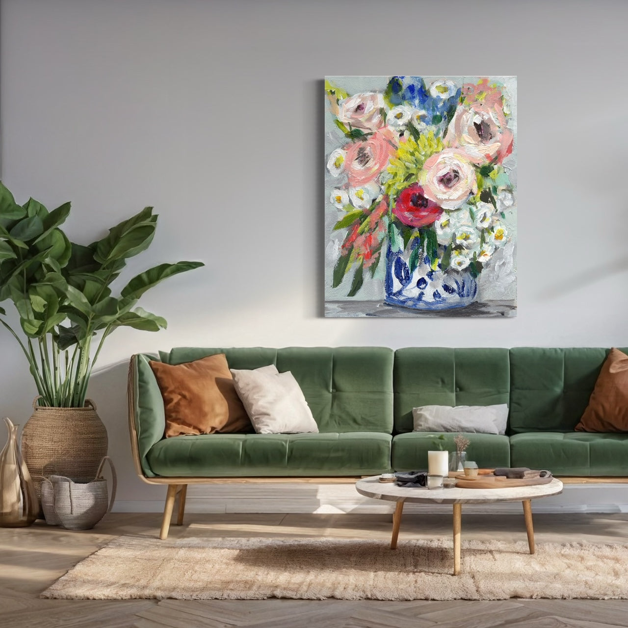 Floral bouquet with colors of pink, red, yellow and white on neutral grey background. Hung on wall with green sofa