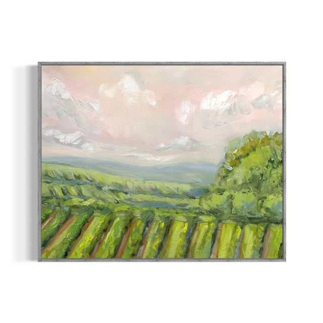 Framed painting of a vineyard landscape with green fields and a pink sky.