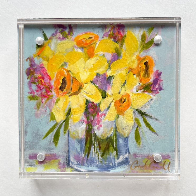 Floral art Print with yellow and orange daffodils and pink accents on light blue background framed in acrylic art frame