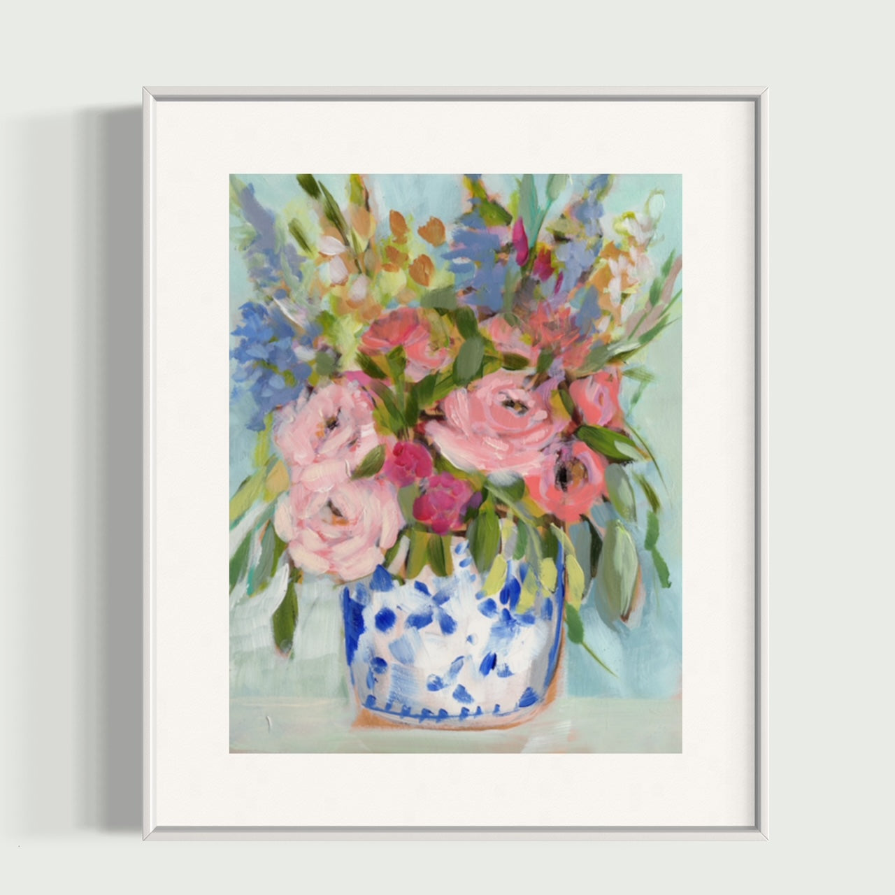 June roses fine art print. Pink peonies, blue hydrangeas and red accents in ginger jar and mint green background. Framed in white frame.