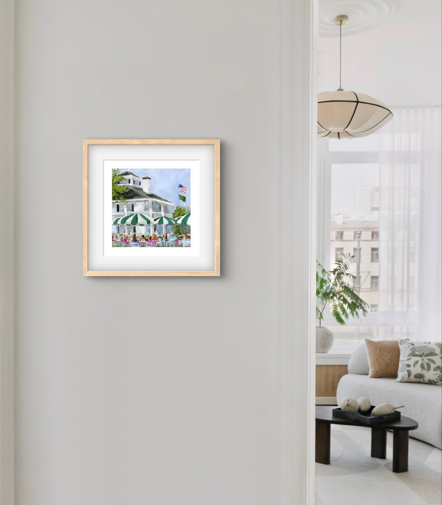 augusta nationals clubhouse golf art print in hallway with neutral wood frame on light gray wall