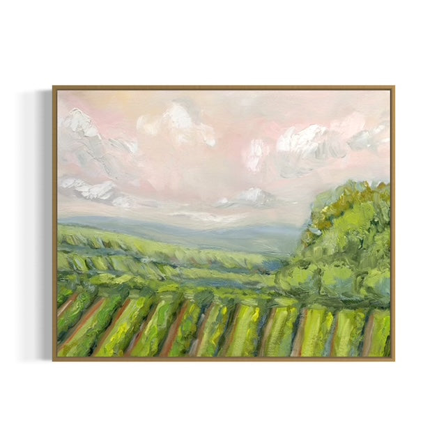 Framed painting of a landscape with green fields and a pink sky.
