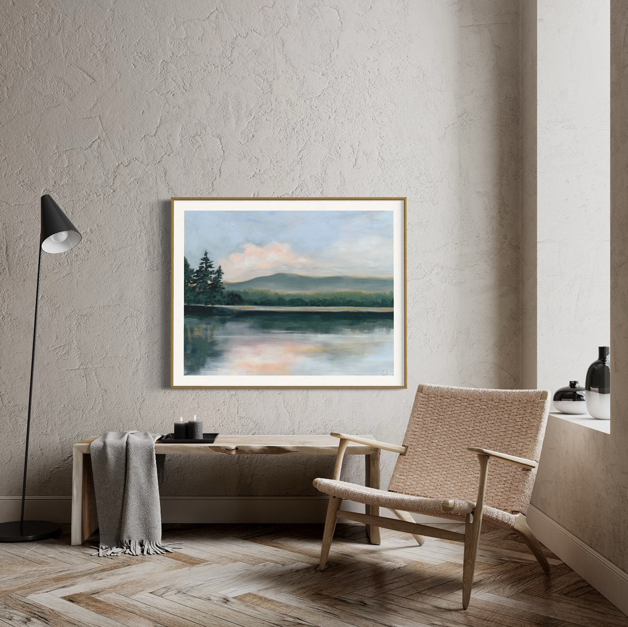 Fine art print of serene lake surrounded by evergreen trees during the golden hour of sunset with neutral chair on stucco wall