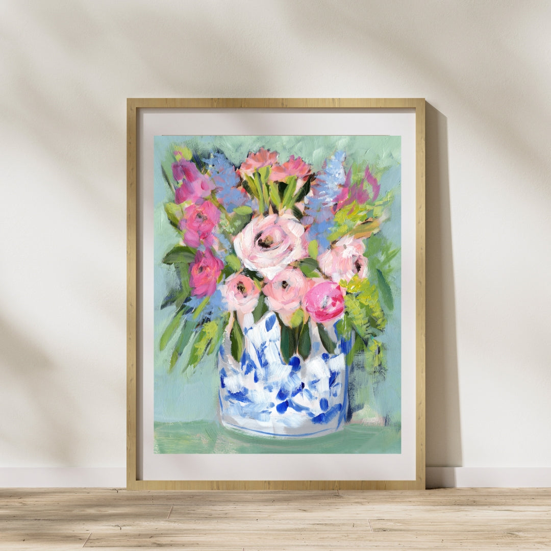 pink, magenta, purple green and aqua floral art print on aqua green background framed in wood frame leaning against wall